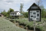 Finn Slough homes at low tide w/ interpretive sign fgnd